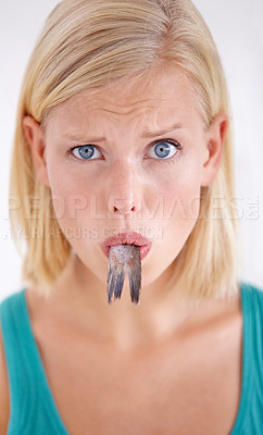 Buy stock photo Confused, woman and portrait eating fish, tail and surprise on white background of studio. Crazy, diet and person with doubt in weird seafood, cuisine and taste gross or strange food in mouth