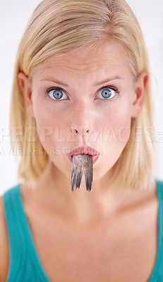 Buy stock photo Eating, fish and portrait of woman with surprise and tail in mouth on white background of studio. Crazy, diet and hungry person with weird cuisine and seafood for sushil, nutrition and shocked face