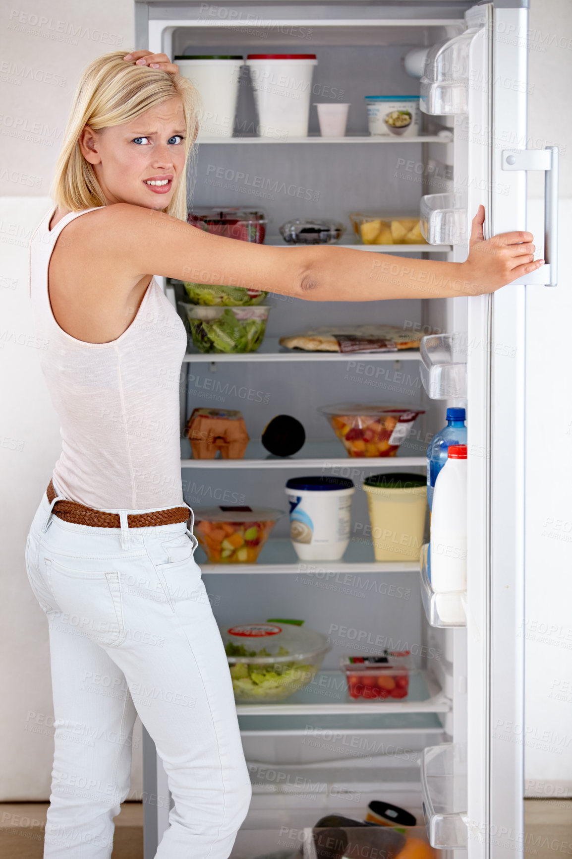 Buy stock photo Portrait of a worried young woman looking in her fridge