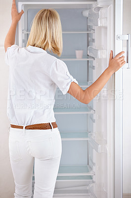 Buy stock photo Rearview of a young woman looking in her empty fridge