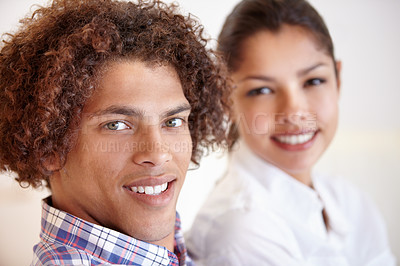 Buy stock photo Shot of a young ethnic couple smiling while sitting together in their home
