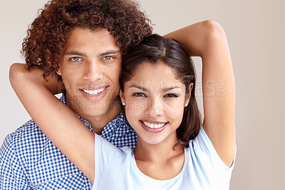 Buy stock photo Studio portrait of a cheerful young ethnic couple embracing and smiling at the camera