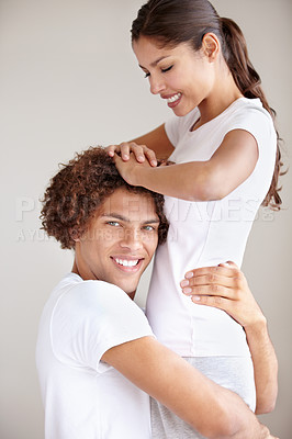 Buy stock photo A happy young ethnic couple embracing each other in a playful way