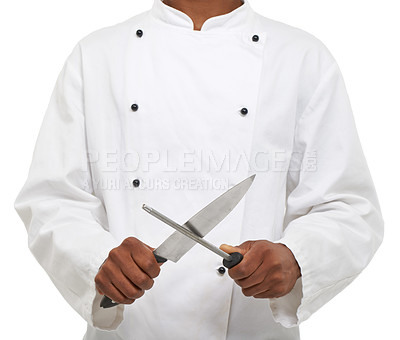Buy stock photo A young chef sharpening his knives while isolated on a white background