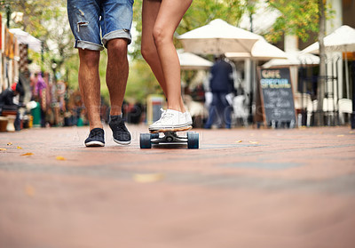 Buy stock photo People, skateboarding and outdoor in city, legs and teaching to ride together for romantic relationship. Cape town, fun and hobby with boyfriend and girlfriend in street, helping and  playful date