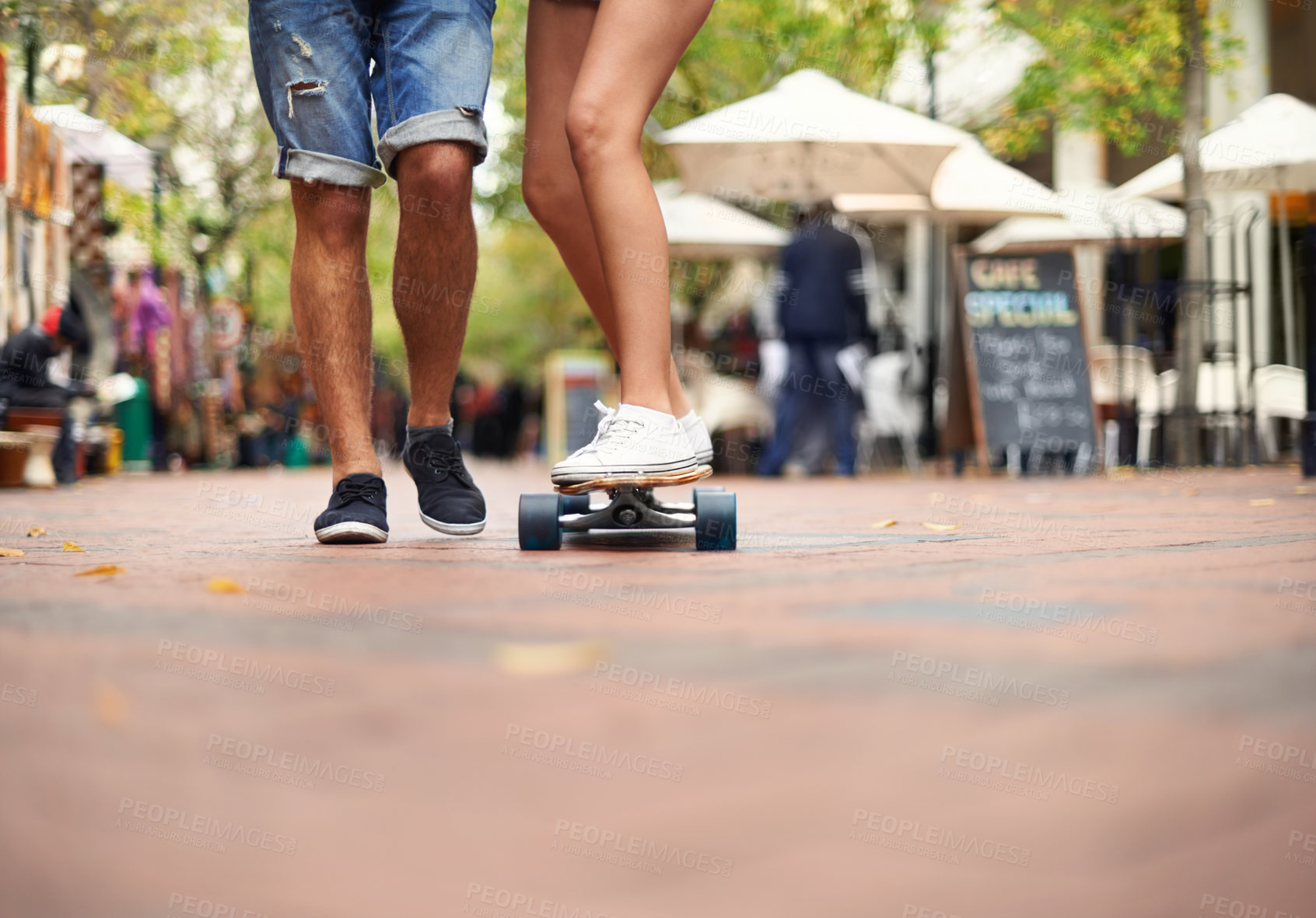 Buy stock photo People, skateboarding and outdoor in city, legs and teaching to ride together for romantic relationship. Cape town, fun and hobby with boyfriend and girlfriend in street, helping and  playful date