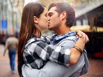 Buy stock photo Shot of a young couple kissing in a downtown street