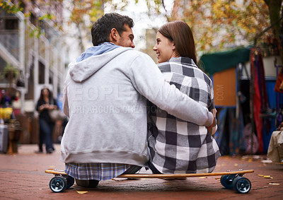 Buy stock photo Couple, sitting on skateboard and outdoor with back, happy and excited to learn together and romantic relationship. Cape town, fun and hobby with boyfriend and girlfriend in street, love and dating