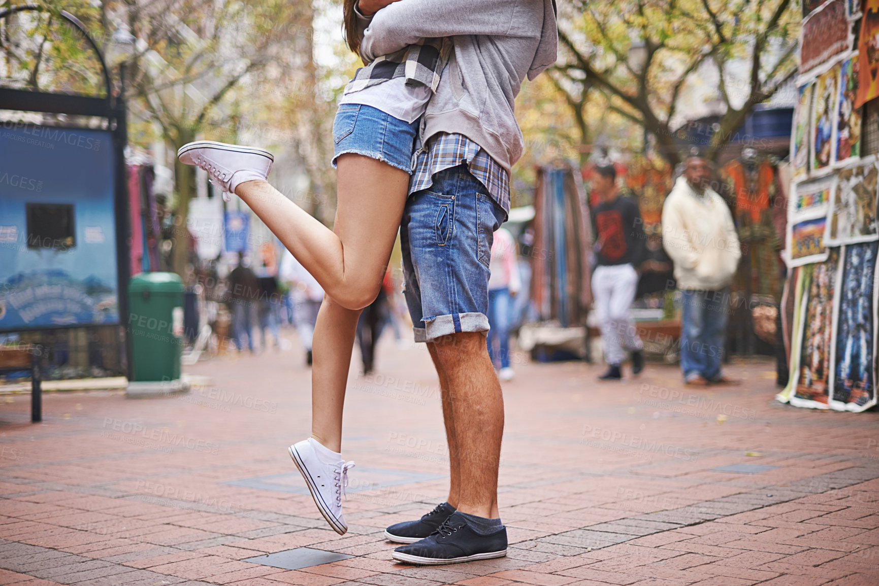 Buy stock photo Waist down cropped shot of an affectionate couple with the girl lifting one of her legs up