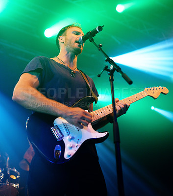 Buy stock photo Attractive musician playing his guitar at a concert