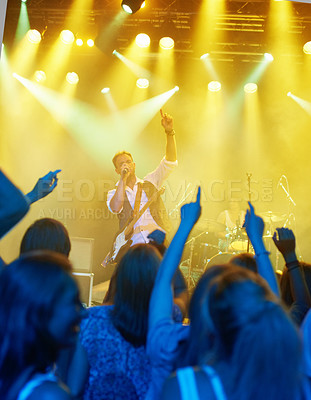 Buy stock photo Man, singing and band or crowd at live concert performance for rock party, music festival or audience. Male people, instruments and hand up or entertainment artist show or listening, weekend or event