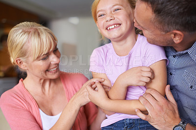 Buy stock photo Family, laughing and parents tickling daughter in living room of home for playful bonding together. Kids, happy or love with mother, father and girl child playing in apartment for comedy or humor