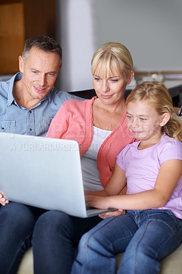 Buy stock photo A family of three using a laptop in the lounge