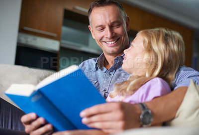 Buy stock photo Father, child and reading a book for learning at home, story and fantasy fiction for education. Daddy, daughter and bonding together on sofa, literacy and storytelling for language development