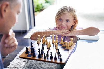 Buy stock photo A father playing chess with his young daughter