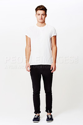 Buy stock photo Studio shot of a young man standing and smiling slightly