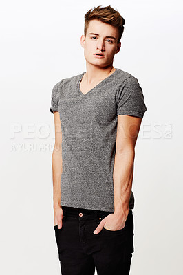 Buy stock photo Studio portrait of a young man standing with hands in pockets and looking at the camera