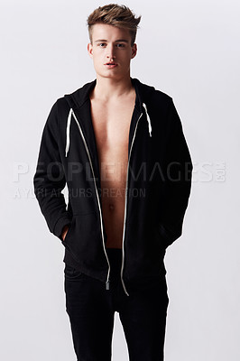 Buy stock photo Studio portrait of young attractive man wearing a hoodie standing with hands in pockets