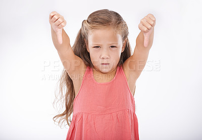 Buy stock photo Thumbs down, girl or portrait of kid in studio for bad news, unhappy emoji sign and vote no on white background. Disappointed child, negative review and fail for decision, wrong results and rejection