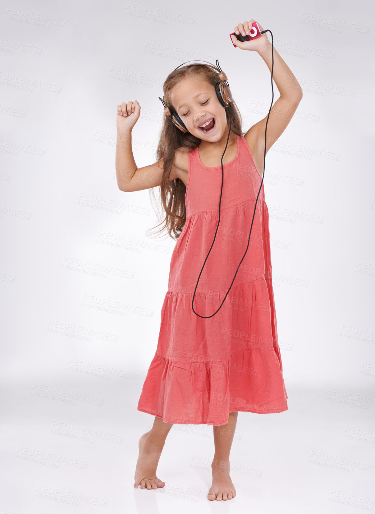 Buy stock photo A young girl listening to music on her head phones and dancing