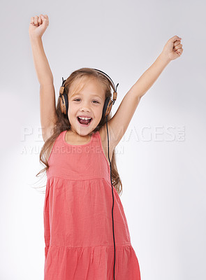 Buy stock photo Portrait of kid, dance and singing with headphones in studio for streaming audio, freedom or celebration on white background. Excited girl child with energy listening to music, hearing sound or radio