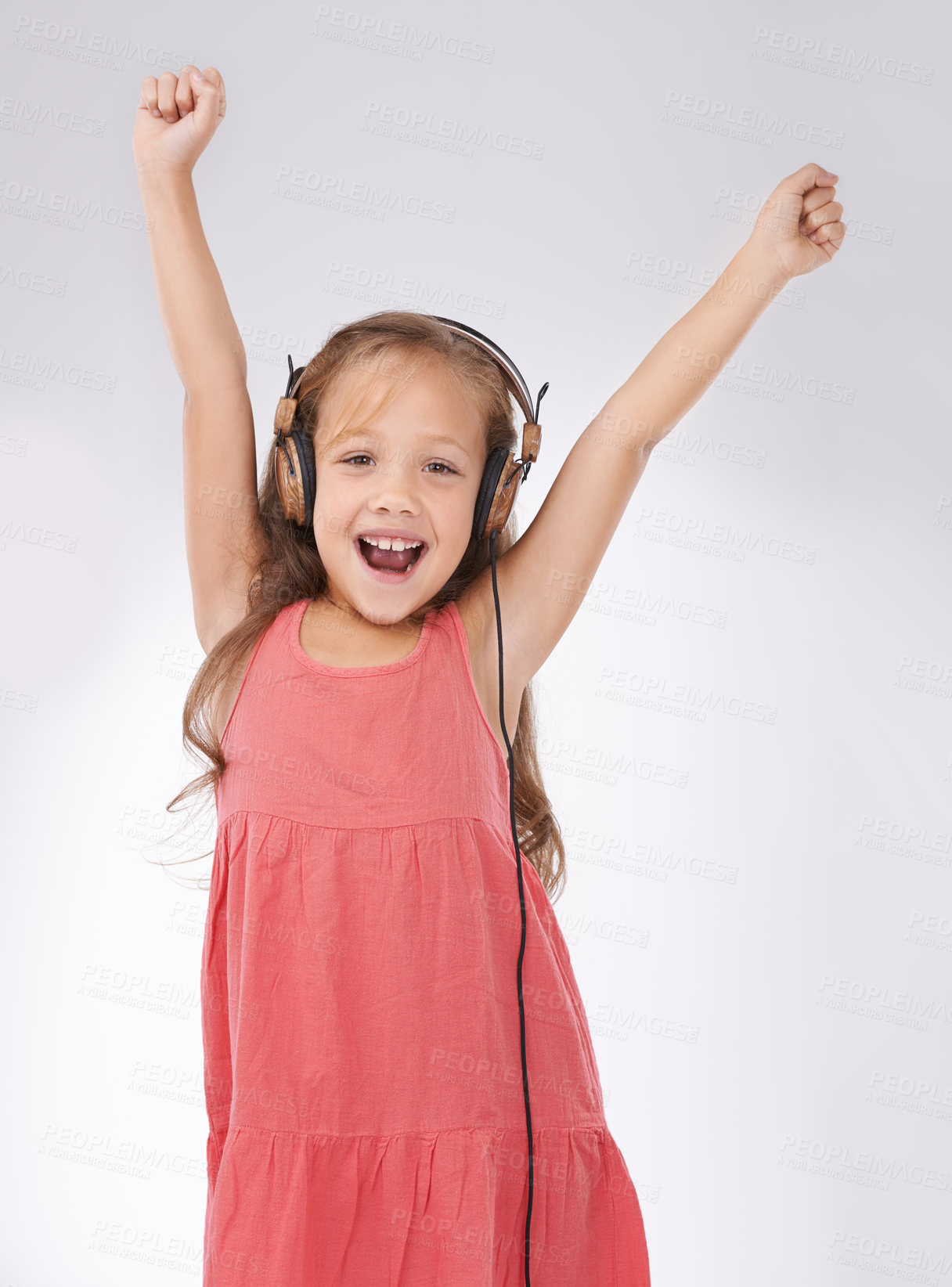 Buy stock photo Portrait of kid, dance and singing with headphones in studio for streaming audio, freedom or celebration on white background. Excited girl child with energy listening to music, hearing sound or radio