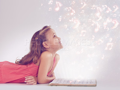 Buy stock photo Child, book and magic fantasy or dream for music listen or storytelling creativity, sound or imagination. Female person, kid and whimsical notes or white background in studio, supernatural or mockup