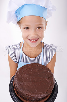 Buy stock photo Kid, baker and portrait with cake, happy and confident with child development on white background. Culinary skills, satisfied and baking dessert and childhood with chocolate in hospitality industry