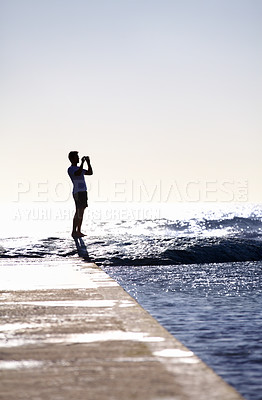 Buy stock photo Silhouette, waves and ocean, man and photography with phone on holiday and travel in Miami, mockup space and summer. Adventure, content creator or influencer with picture for blog and sea view