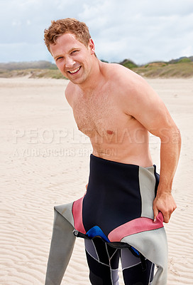 Buy stock photo Portrait, smile and surfer man in wetsuit at beach for sports, fitness or exercise on summer vacation. Travel, health and sand with happy young person getting for training, workout or surfing