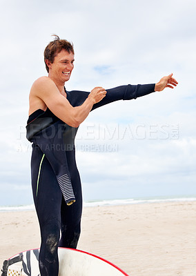 Buy stock photo A young surferputting on his wetsuit