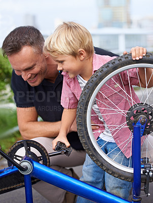Buy stock photo A handsome father showing his son the different parts of a bike 