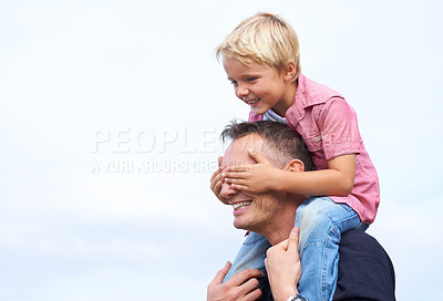 Buy stock photo Shot of a playful father giving his son a piggyback outside