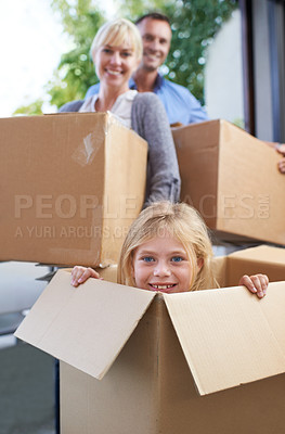 Buy stock photo Moving, portrait and girl in box with parent, fun in new home and happy package with mortgage. Mother, father and playful child in cardboard with smile, hiding and property investment for family.