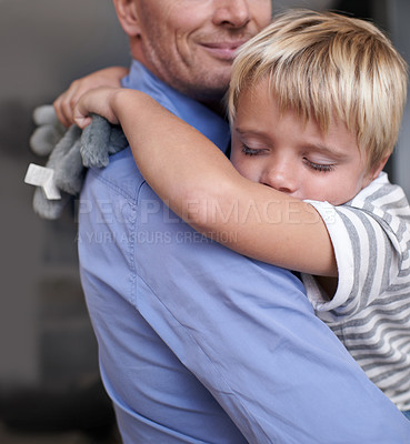 Buy stock photo A mature father coming home from work and hugging his exhausted little boy