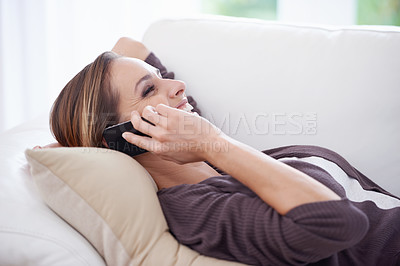 Buy stock photo Woman, laughing and relax on sofa for phone call, digital communication and mobile networking at home. Happy lady, cellphone or chat for audio contact, funny conversation or gossip on couch in lounge