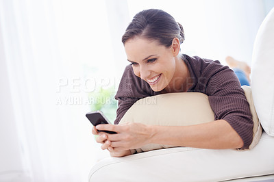 Buy stock photo Woman, smile and typing with phone on sofa, scroll social media or reading chat notification in lounge at home. Happy lady, relax or download digital app, mobile games or search contact on smartphone