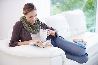 Buy stock photo Woman, book and reading with coffee on sofa to relax for story, novel and knowledge in living room at home. Lady, fiction books and break with cup of tea for literature, hobby or comfortable on couch