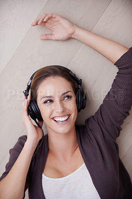Buy stock photo Top view, headphones or happy woman on floor for music streaming, mental health or wellness. Smile, thinking or fun female person on break listening to audio, radio song or track to relax in home