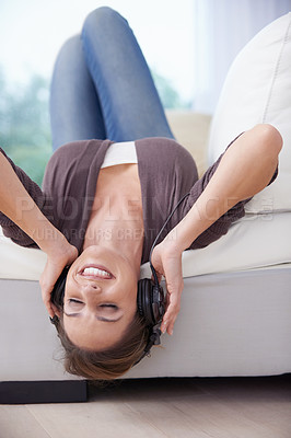 Buy stock photo Woman, upside down on sofa and headphones for music, audio streaming and happiness, stress relief and fun at home. Podcast, radio playlist and subscription online, relax in living room with tech