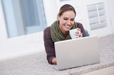 Buy stock photo Woman, laptop and relax with coffee, happy with tech and streaming online for video or movie with internet at home. Connectivity, film or tv show, lying on carpet or floor for entertainment and drink