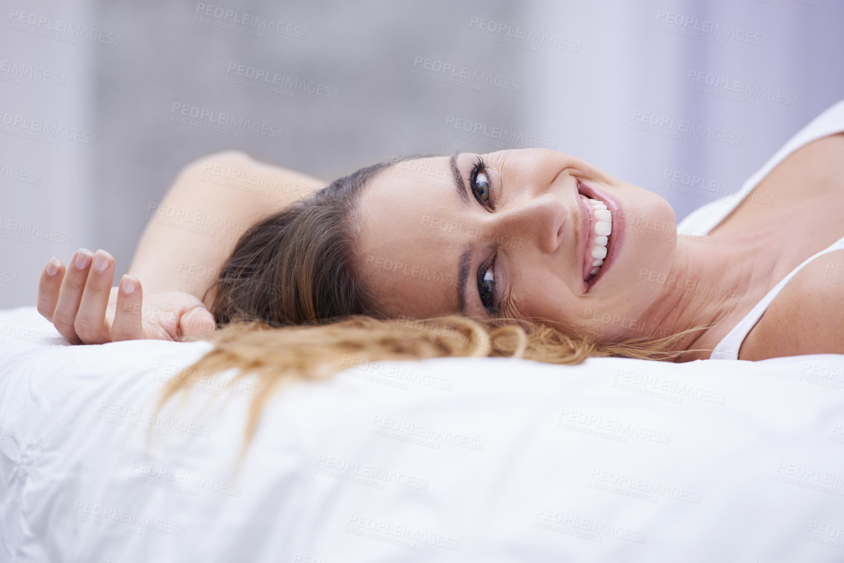 Buy stock photo Woman, portrait and comfortable in bed on weekend, lazy and relaxation on morning at home. Female person, smile and satisfaction while resting in bedroom, wake up and good mood on vacation or holiday