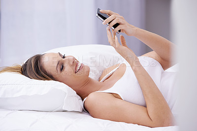 Buy stock photo Happy woman, relax on bed and phone for social media, reading online and communication or streaming. Young person in bedroom with mobile for chat, contact and internet connection for home on weekend