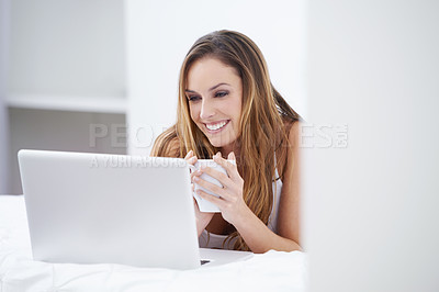 Buy stock photo A beautiful woman using her laptop from the comfort of her bed