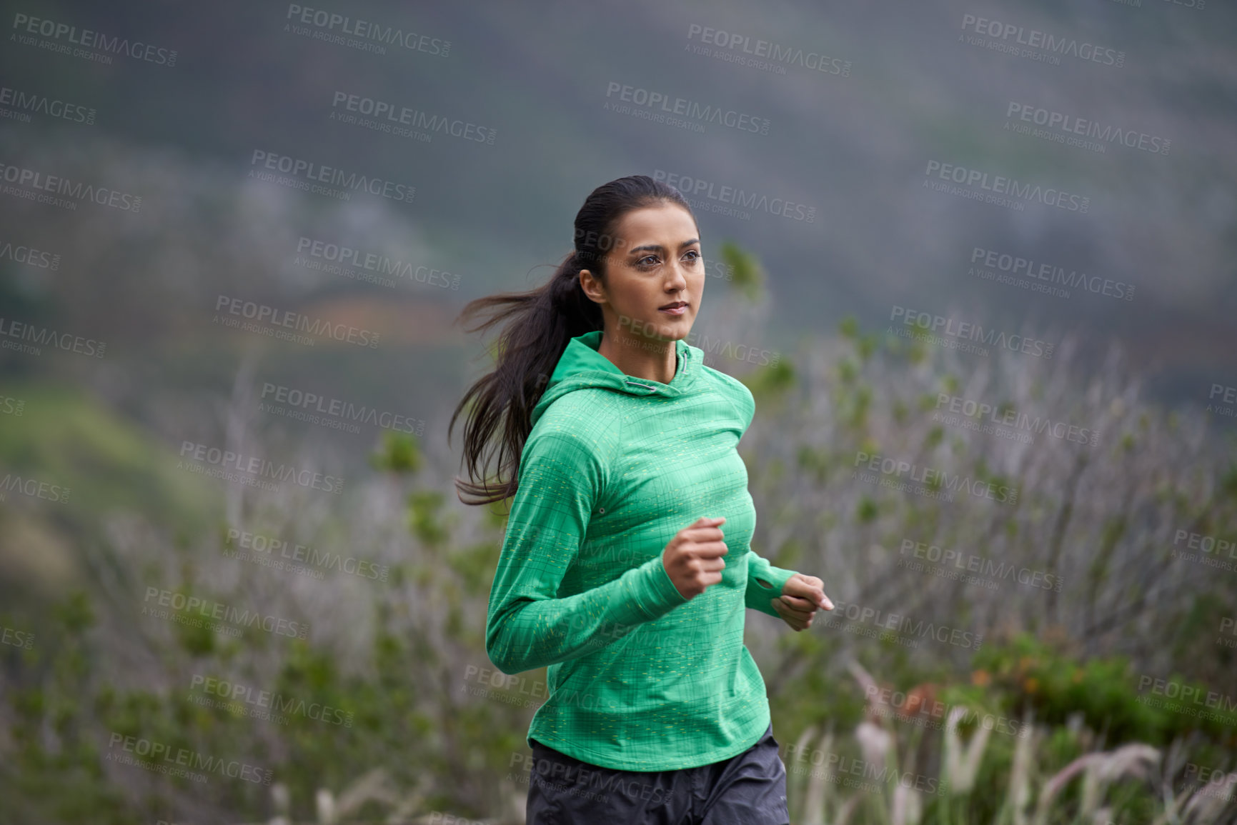 Buy stock photo Shot of a beautiful young woman exercising in the mountains