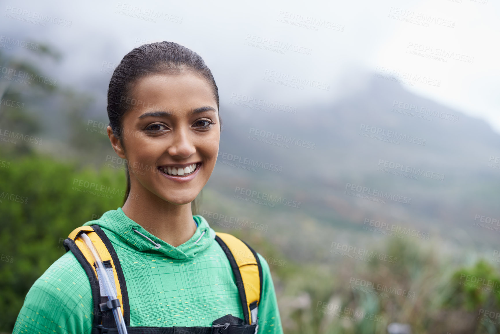 Buy stock photo A beautiful young woman standing against a backdrop of scenic mountains about to go for a hike