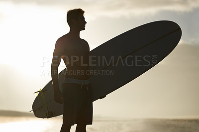Buy stock photo Surfing, sunset and silhouette of man at a beach with surfboard for freedom, travel or sports outdoor. Ocean, training and surfer shadow at sea for swimming, wellness or adventure, workout or holiday
