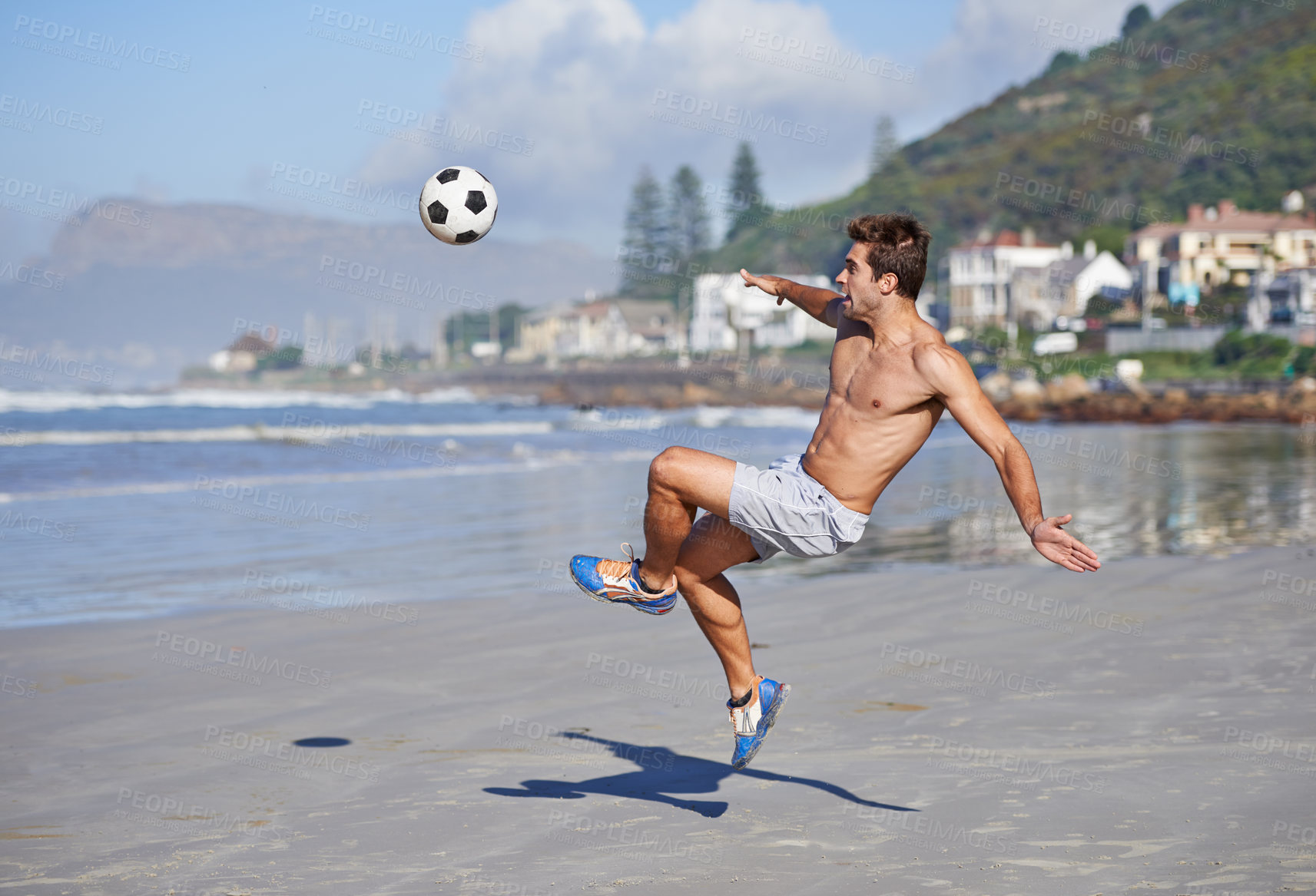 Buy stock photo Man, beach and volley with soccer ball for game, sports or exercise in outdoor hobby, training or practice. Young male person or football player kicking in match or cardio workout by ocean coast
