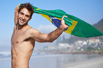 Buy stock photo Man, brazil flag and portrait for happiness at beach, outdoor fun and happy in summer on vacation. Young person, face or holiday by sea in freedom or soccer competition by ocean for travel adventure