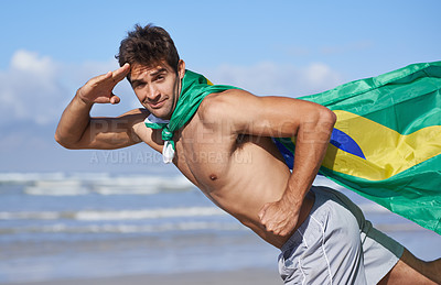Buy stock photo Man, portrait and Brazilian flag on beach for patriotic pride or outdoor support for Country, nationality or nature. Male person, face and hand salute at ocean for holiday, vacation or citizenship